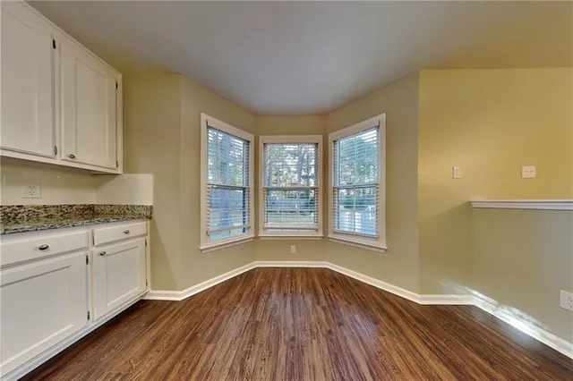 a view of a kitchen with wooden floor and a window
