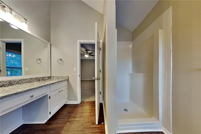 a bathroom with a granite countertop sink mirror and shower