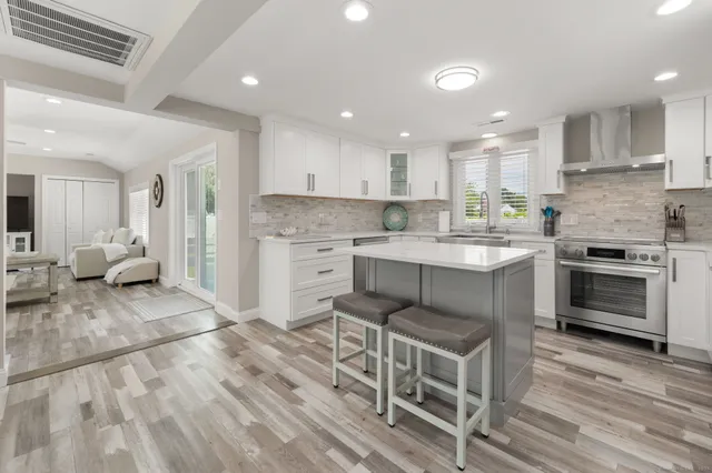 a kitchen with white cabinets and a stove top oven