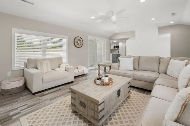 a living room with furniture a flat screen tv and a window