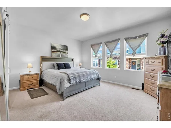 a bedroom with a bed and a large window