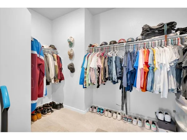 a view of walk in closet with clothes