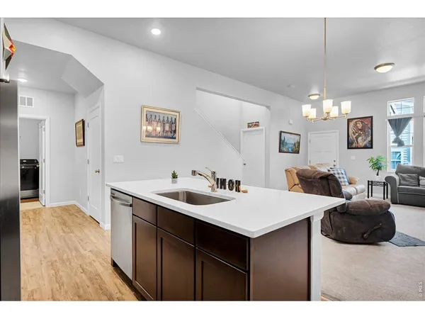 a living room with furniture a chandelier and a flat screen tv