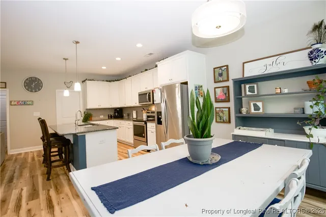 a kitchen with a dining table wooden floor and a fireplace
