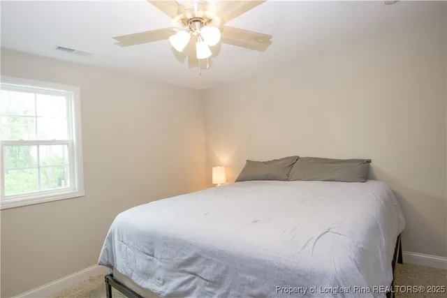 a large bed sitting in a bedroom next to a window