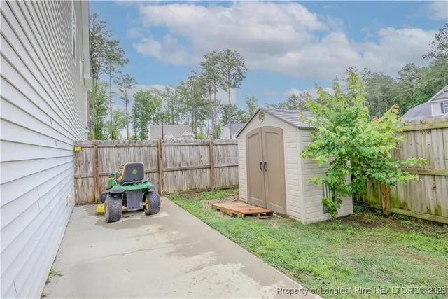 a view of a chair and table in backyard of the house