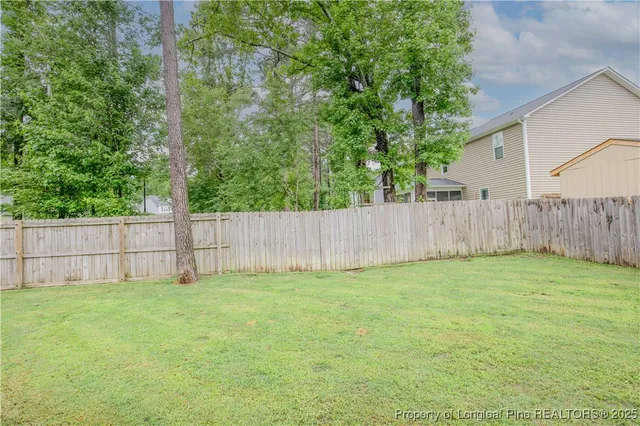 a view of a backyard with a house and wooden fence