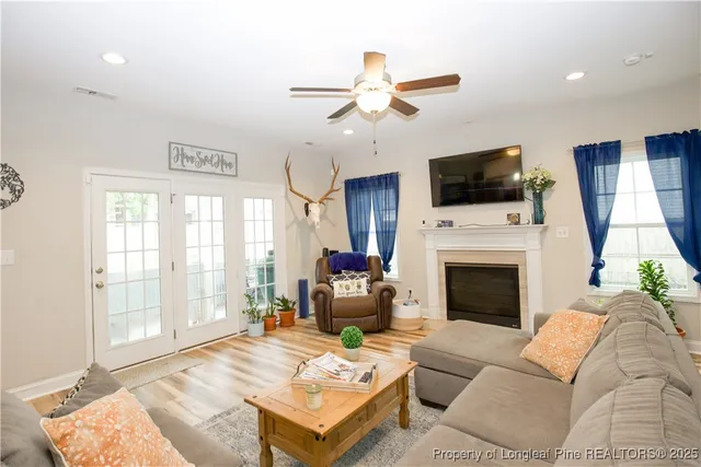 a living room with furniture a fireplace and a flat screen tv