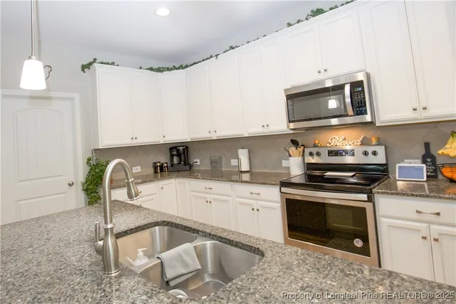 a kitchen with a stove a sink and a microwave