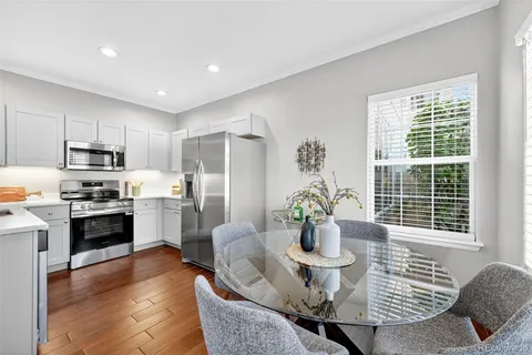 a kitchen with sink refrigerator dining table and chairs