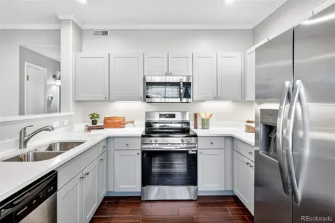 a kitchen with stainless steel appliances granite countertop a stove a sink and a refrigerator