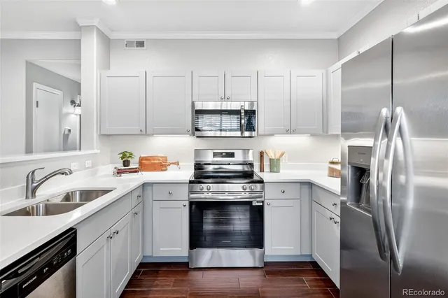 a kitchen with stainless steel appliances granite countertop a stove a sink and a refrigerator