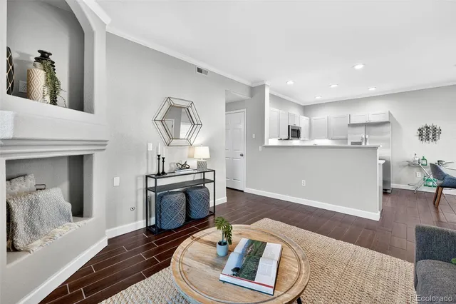 a living room with stainless steel appliances furniture and a kitchen view