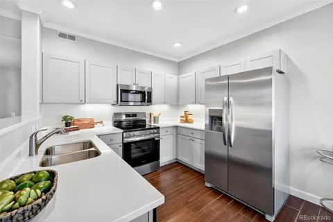a kitchen with a refrigerator a sink a stove and cabinets