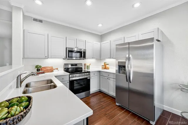 a kitchen with a refrigerator a sink a stove and cabinets