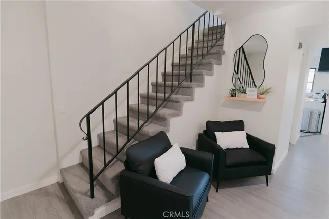 a living room with wooden floor and a rug