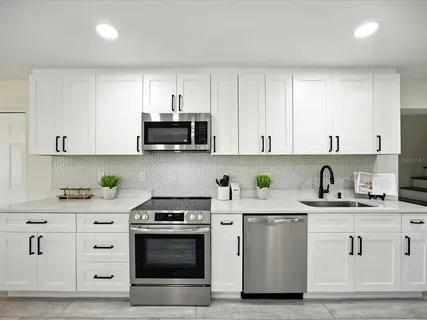 a bedroom with a bed a couch and a potted plant