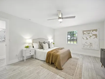 a bedroom with a large bed and a chandelier