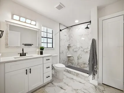 a bathroom with a toilet sink and mirror