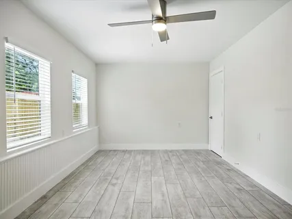 a view of empty room with wooden floor