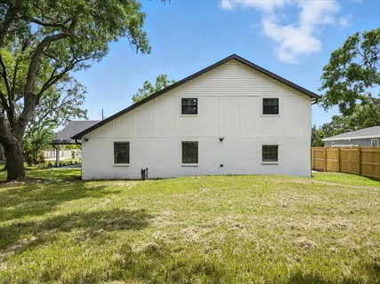an aerial view of residential houses with outdoor space and trees