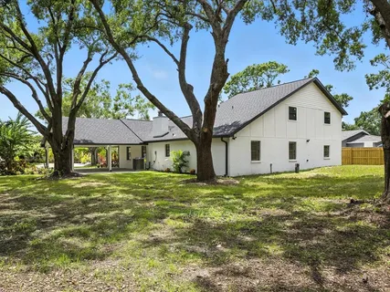 an aerial view of residential houses with outdoor space and trees