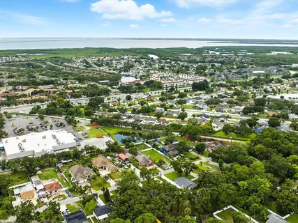an aerial view of residential houses with outdoor space and trees all around
