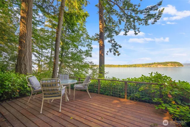 a view of a chairs and table in patio with a lake view