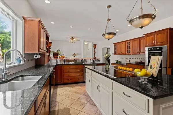 a kitchen with granite countertop a sink a counter top space appliances and cabinets