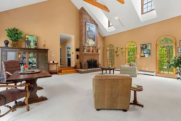 a living room with fireplace furniture and a large window