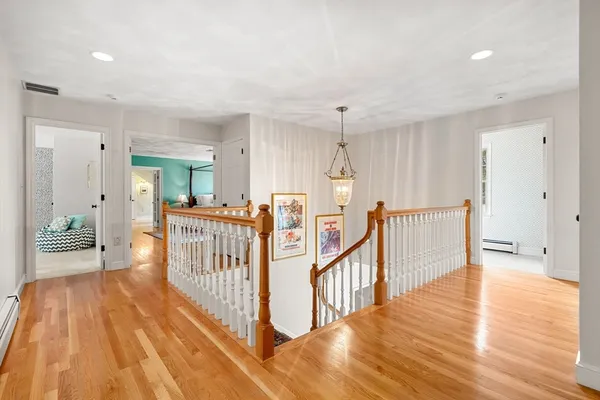 a view of a hallway with wooden floor and stairs