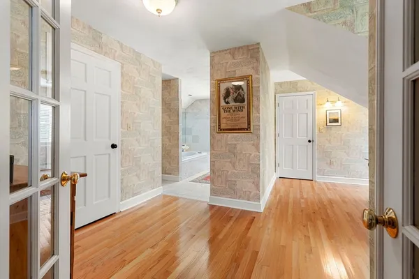 a view of a hallway with wooden floor and staircase