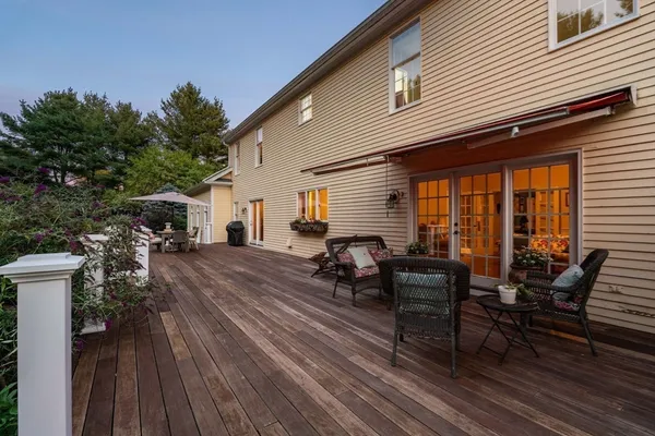 a view of a patio with table and chairs with wooden floor and fence