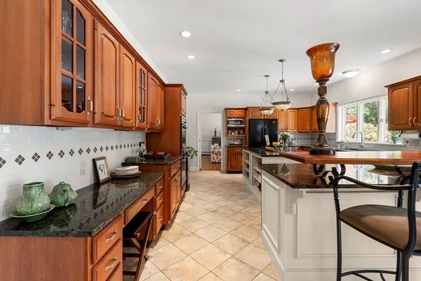 a kitchen with stainless steel appliances granite countertop a stove a sink and a refrigerator