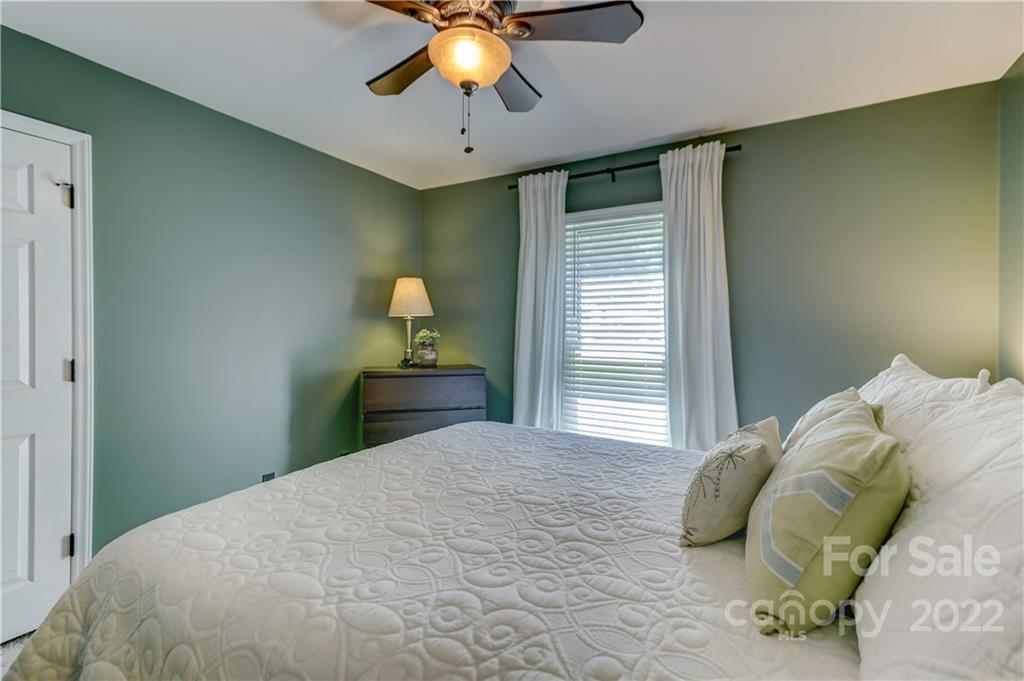 6023 Lanai Lane Tega Cay, SC 29708 - Photo 33 of 43 a bedroom with a bed and a chandelier