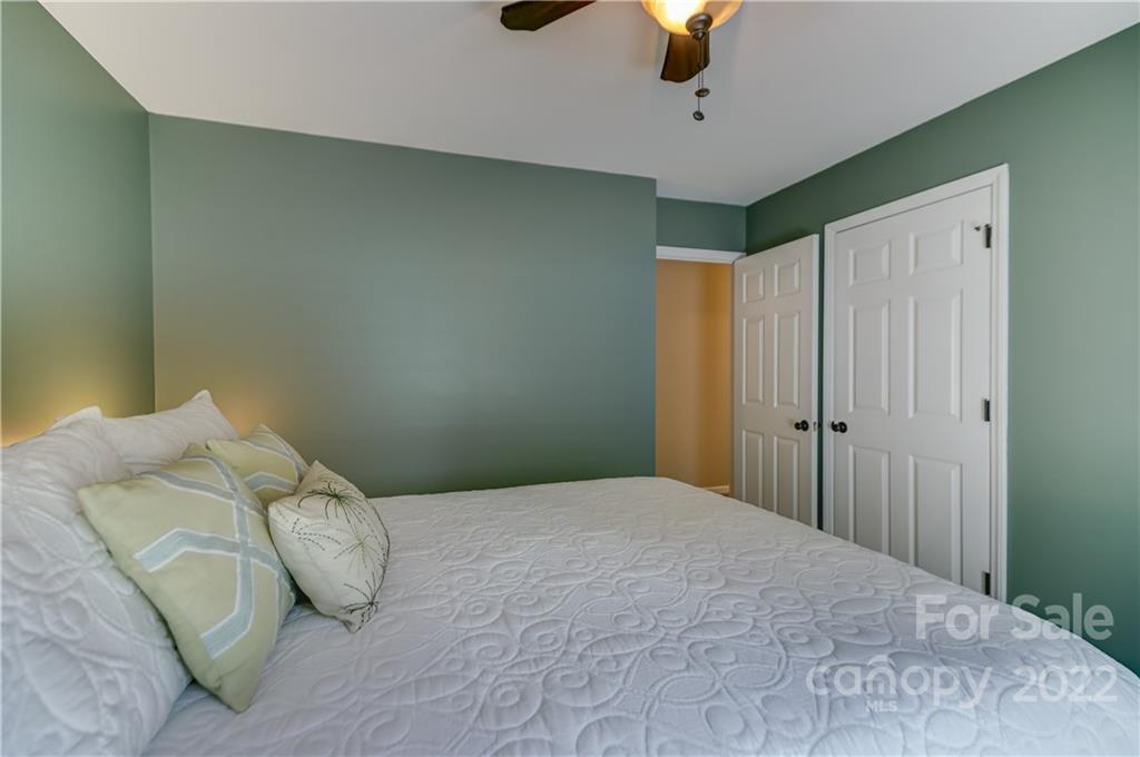 6023 Lanai Lane Tega Cay, SC 29708 - Photo 35 of 43 a bedroom with a bed and a chandelier