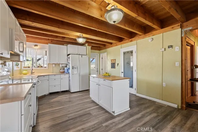 a kitchen with a refrigerator and white cabinets