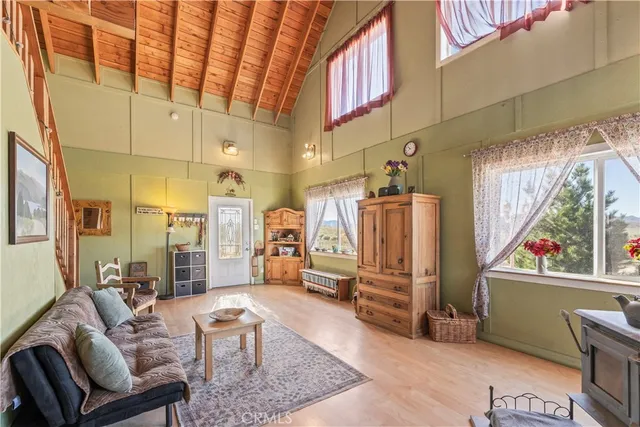 a living room with furniture a rug and kitchen view