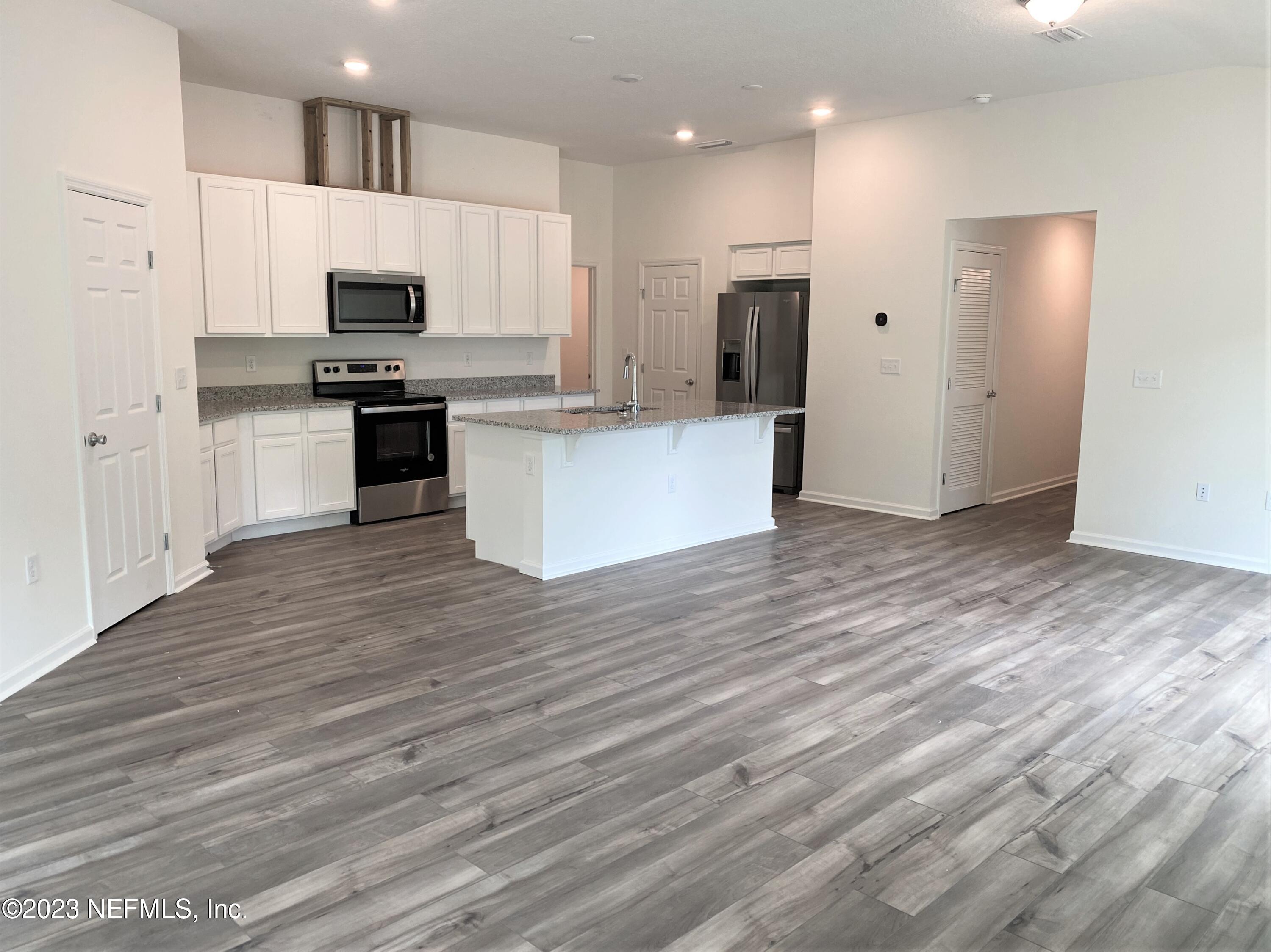 11611 Double Eagle Court Jacksonville, FL 32221 - Photo 5 of 9 a large kitchen with cabinets wooden floor and stainless steel appliances