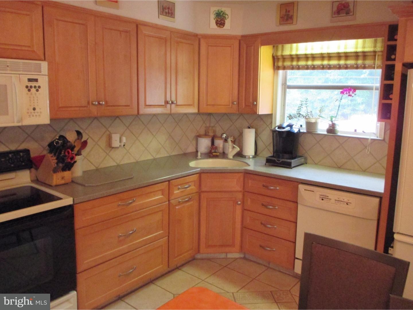 641 Kismet Road Philadelphia, PA 19115 - Photo 12 of 25 a kitchen with granite countertop white cabinets stainless steel appliances a sink and a window