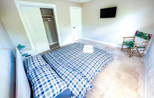 a bedroom with a bed and a flat screen tv