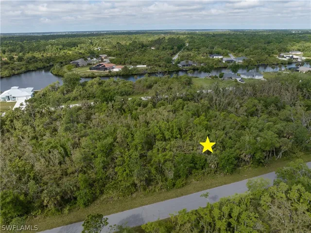 an aerial view of residential houses with outdoor space and trees