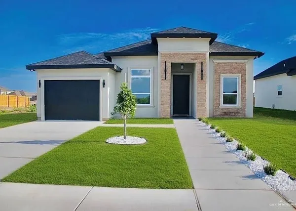 a front view of a house with a garden and yard