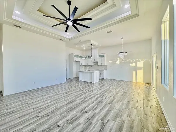 a view of empty room with wooden floor and ceiling fan