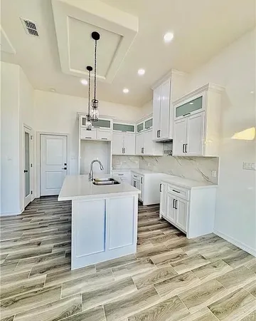 a kitchen with stainless steel appliances kitchen island a sink stove and cabinets