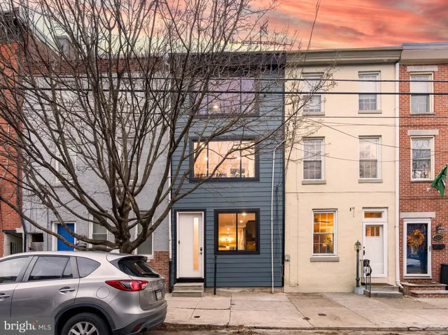 a front view of a building with large tree