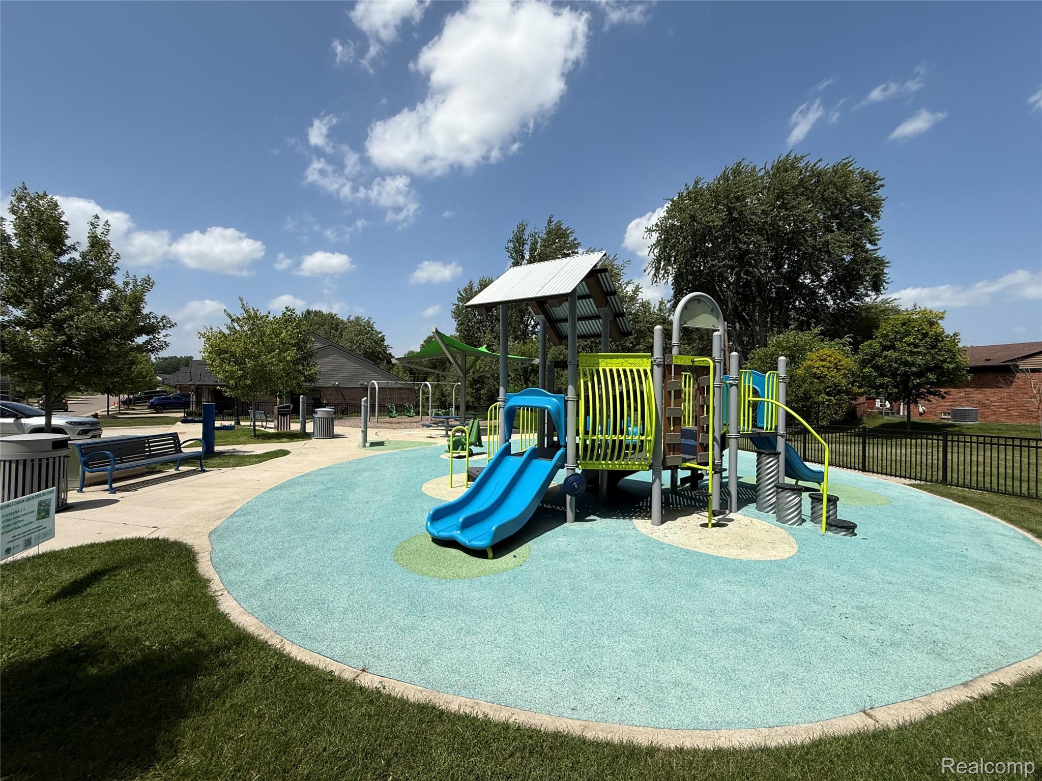 39909 Lynn Street Canton, MI 48187 - Photo 43 of 45 Modern playground featuring multiple slides, climbing structures, and protective surfacing
