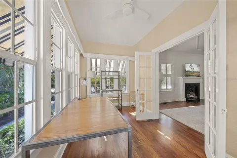 a view of a hallway with wooden floor and windows