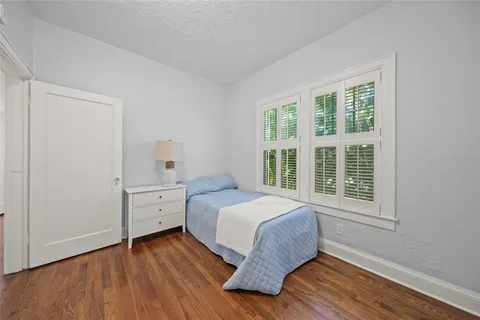 a bedroom with a bed and wooden floor