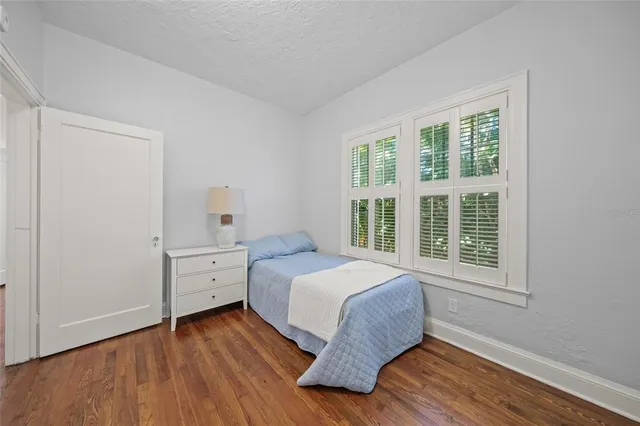 a bedroom with a bed and wooden floor